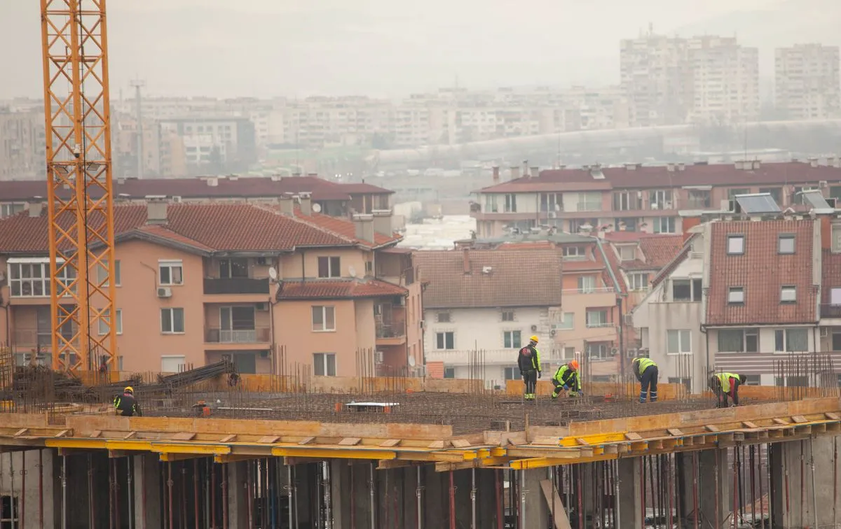 Muncitor pe santier intr-un apartament in renovare, pereti desfacuti si unelte