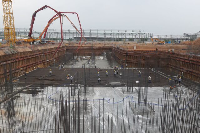 Perete de fundație acoperit cu membrană hidroizolantă neagră, pe un șantier de construcții